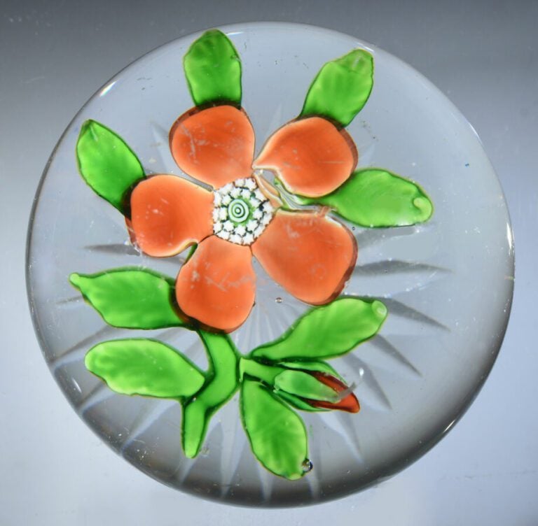 Baccarat. - Presse-papiers orné d'une primevère orange à cinq pétales sur une t…