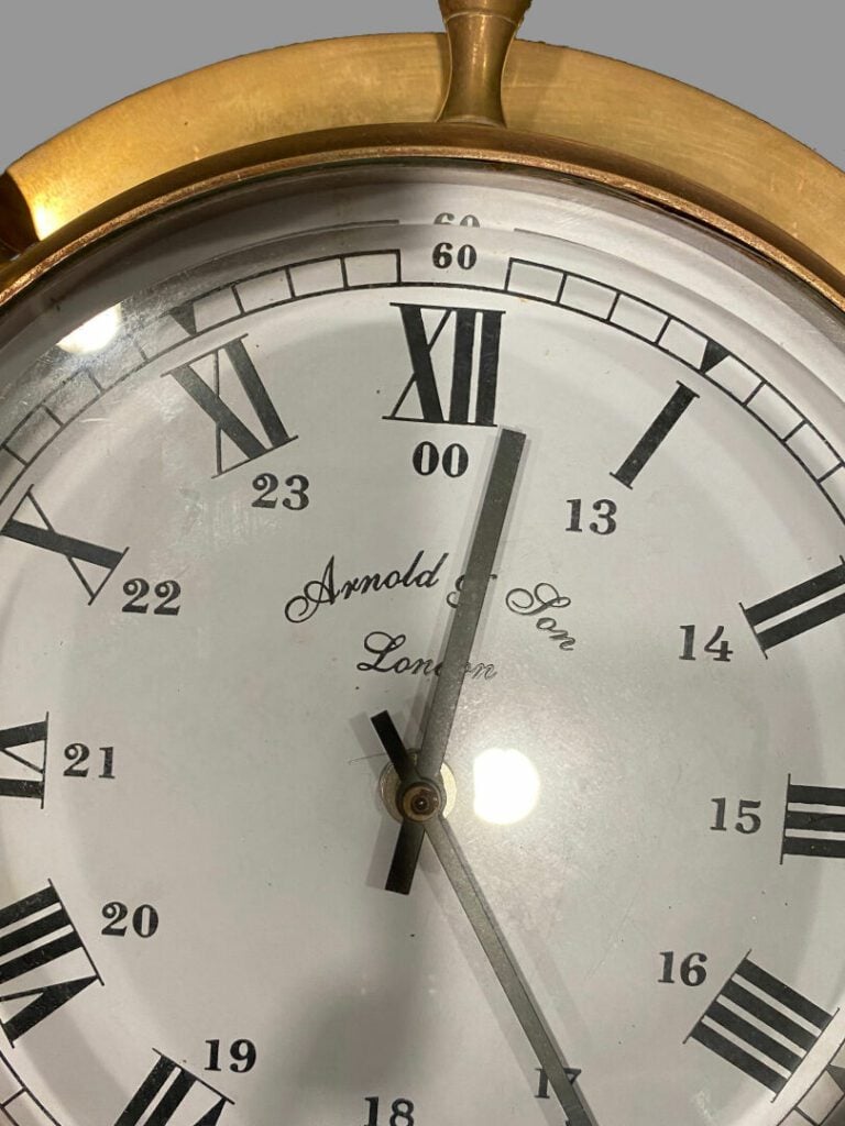 ARNOLD & SON London - Pendule en bronze en forme de barre à roue, cadran à fond…