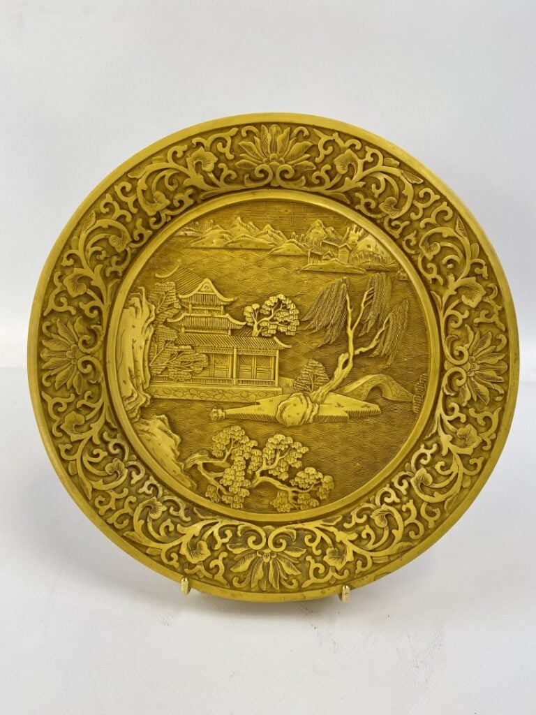 Assiette dans le goût des laques de cinabre - Chine - Dans le médaillon central…