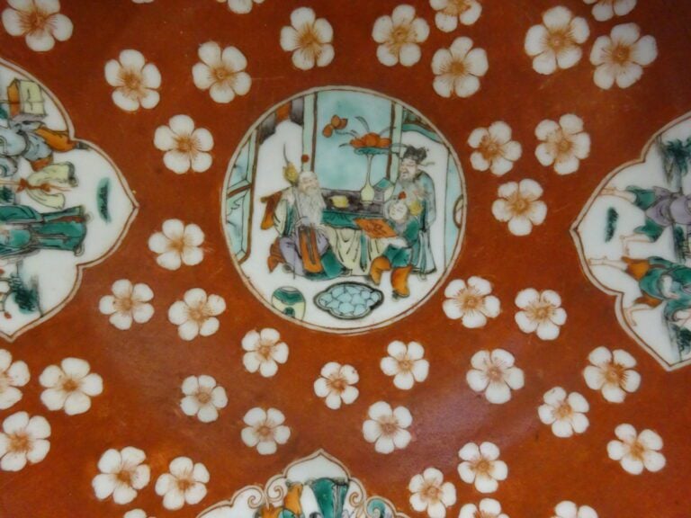 [-] ASSIETTE EN PORCELAINE A FOND ROUGE - Chine, - Décor aux médaillons où s'in…