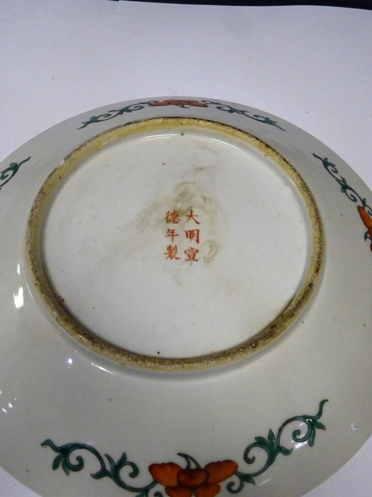 [-] ASSIETTE EN PORCELAINE A FOND ROUGE - Chine, - Décor aux médaillons où s'in…