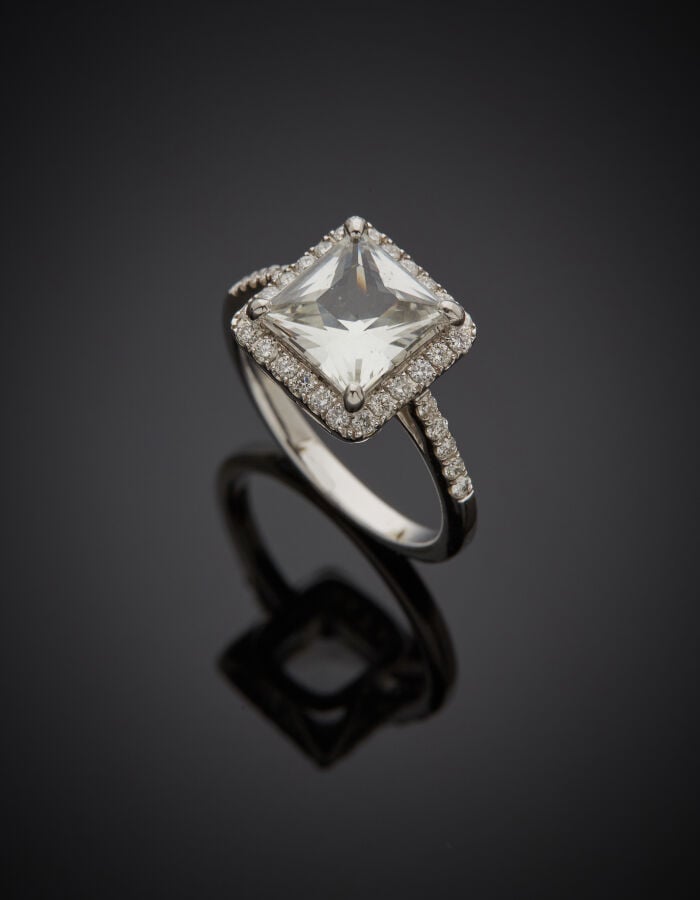 BAGUE carrée en or gris (750‰) serti d'un saphir incolore carré pesant 2 carats…