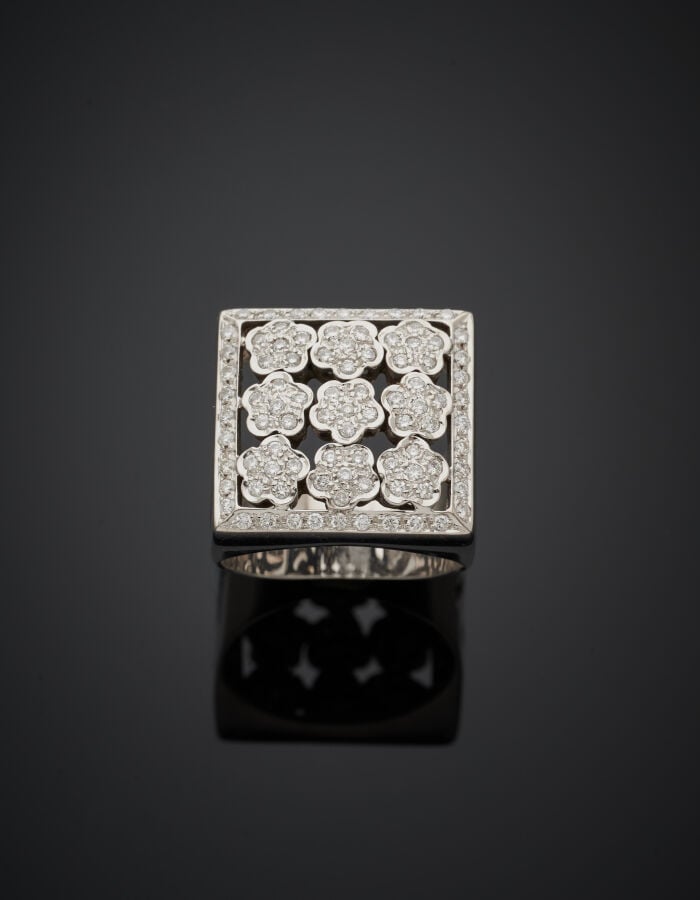BAGUE "chevalière" carrée en or gris (750‰) ajouré, à motifs de neuf fleurettes…