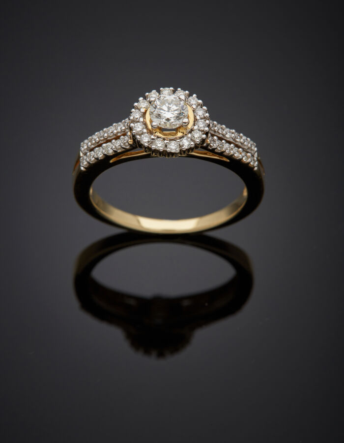 BAGUE circulaire en or jaune (585‰) 14 carats, serti d'un diamant taille brilla…