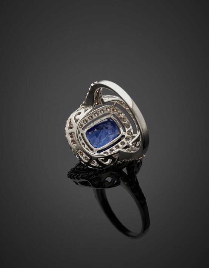 BAGUE "coussin" en or gris (750‰) ajouré, serti d'un saphir de forme coussin (p…