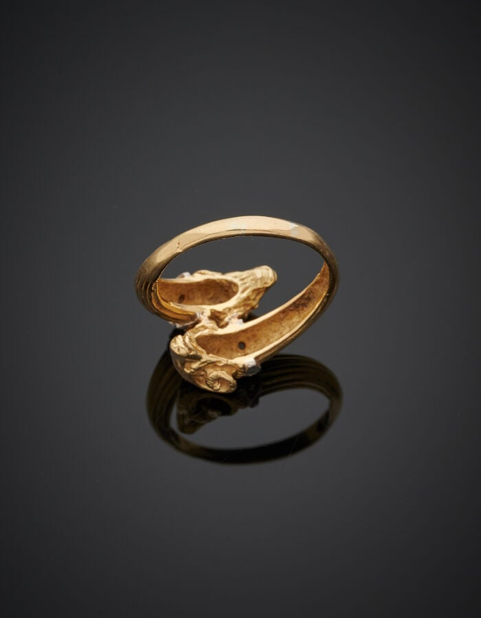 BAGUE "deux béliers" en or jaune et gris (750‰) ciselé, godronné, serti de diam…