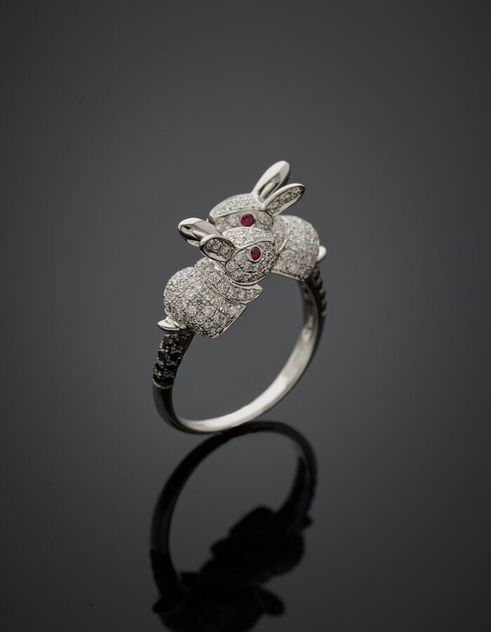 BAGUE "deux lapins" en or gris (750‰) sculpté, pavée de diamants blancs et noir…