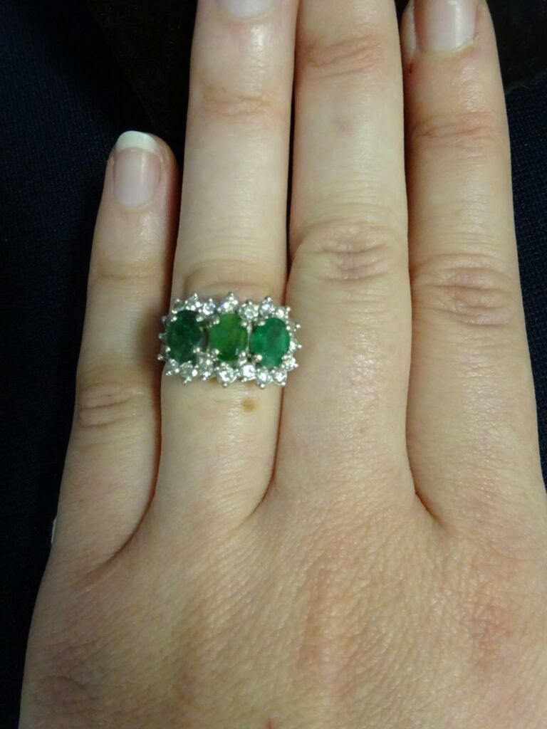 Bague en or gris 750 millièmes, ornée de trois émeraudes ovales dans un entoura…