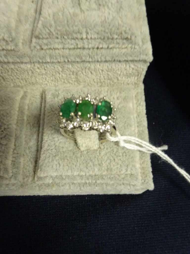 Bague en or gris 750 millièmes, ornée de trois émeraudes ovales dans un entoura…
