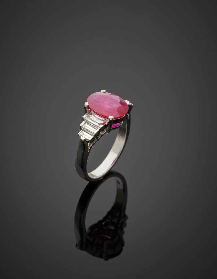 BAGUE en or gris (750‰) serti d'un rubis pesant 2,84 carats, épaulé de six diam…