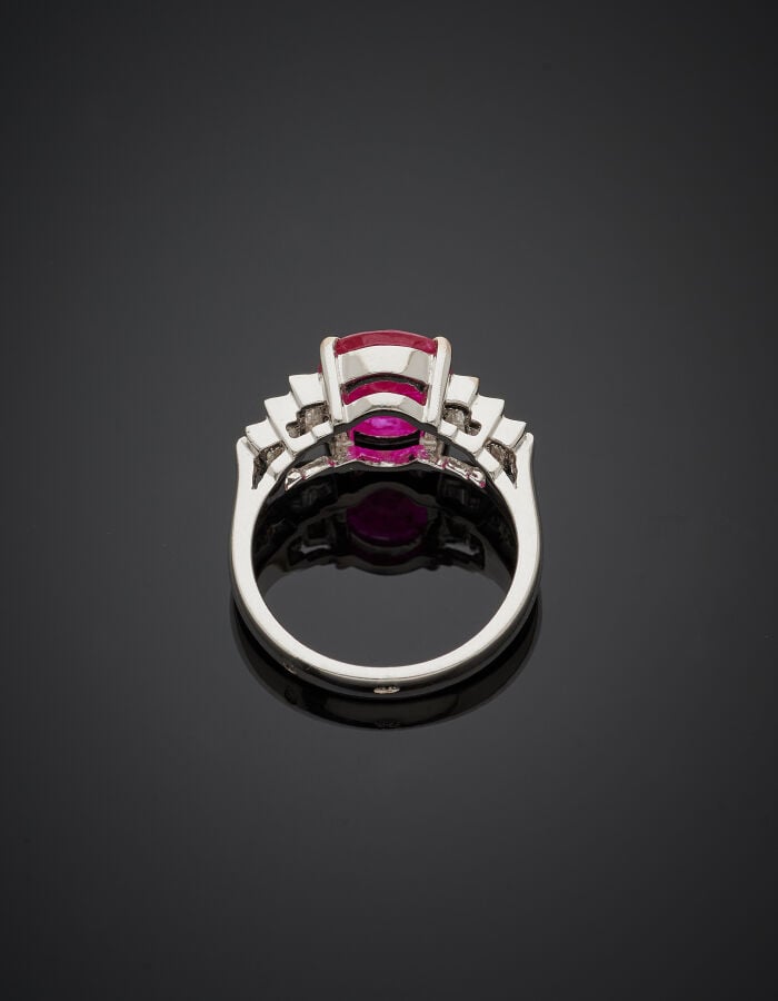 BAGUE en or gris (750‰) serti d'un rubis pesant 2,84 carats, épaulé de six diam…