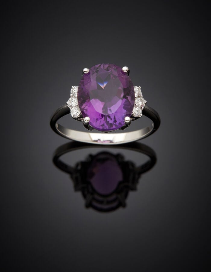 BAGUE en or gris (750‰) serti d'une améthyste ovale, épaulée de six diamants ta…