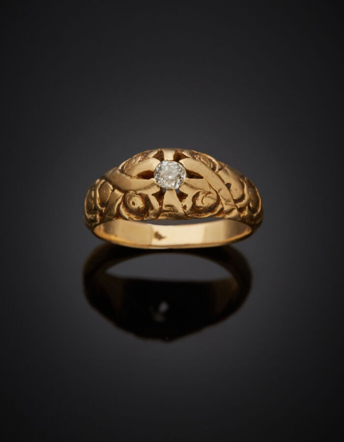 BAGUE en or jaune (750‰) ajouré à motifs de volutes, serti d'un petit diamant t…