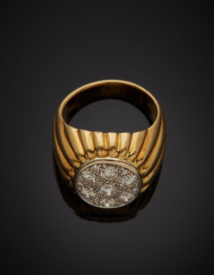 BAGUE en or jaune et or gris (750‰) godronné, surmontée d'un pavage de diamants…