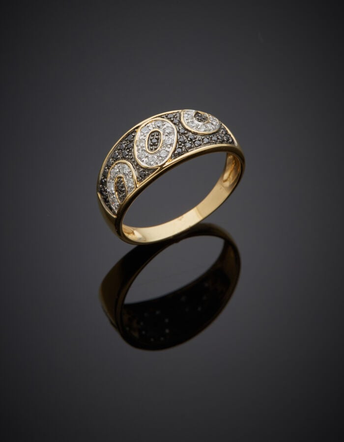 BAGUE en or jaune, gris et or noirci (750‰) pavé de diamants noirs et blancs, à…