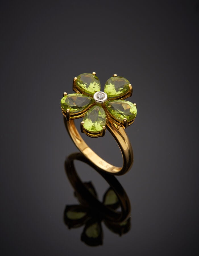 BAGUE "fleur" en or jaune (750‰) ajouré, serti de cinq péridots taillés en poir…