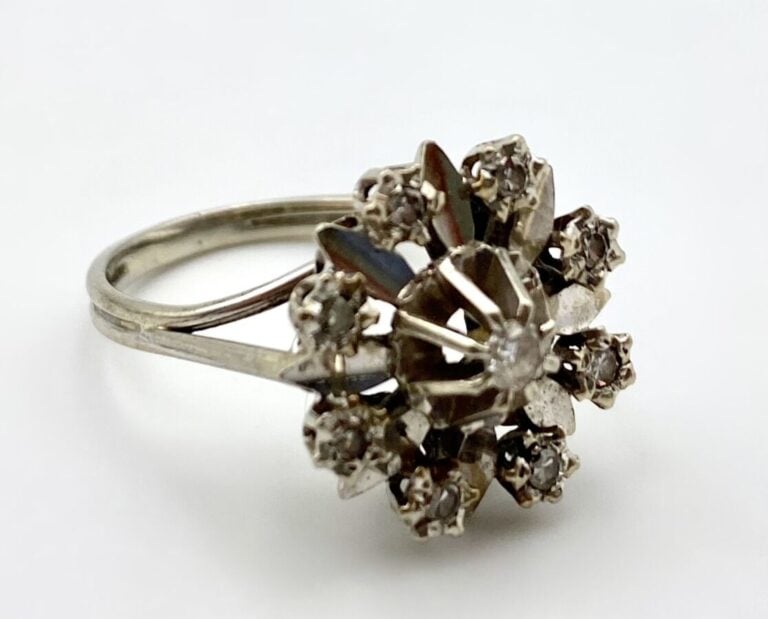 BAGUE "Fleurette" en or blanc ( 750 ‰ ) ajouré, serti de huit petites pierres b…