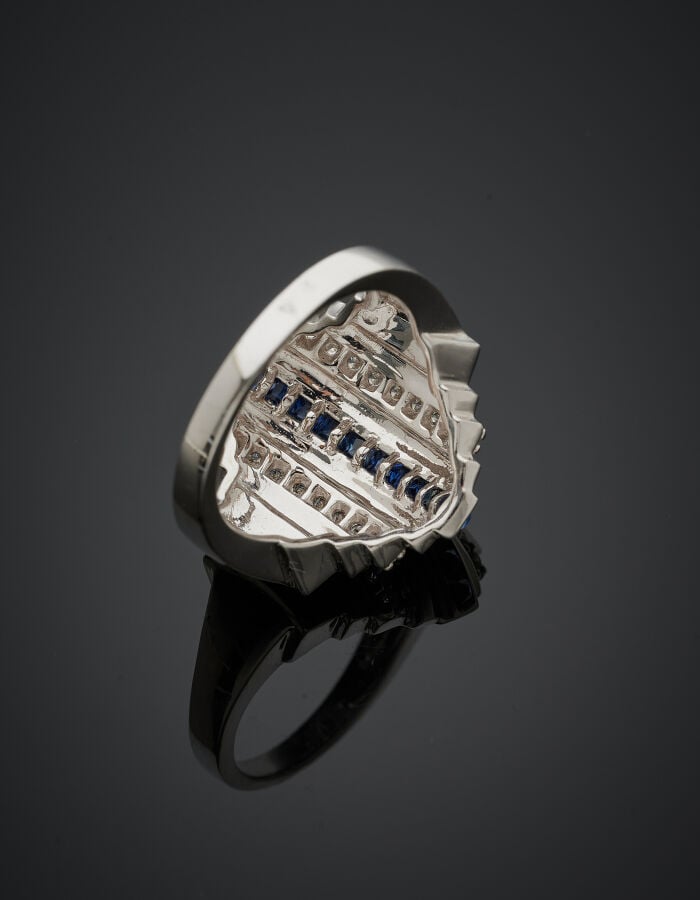 BAGUE géométrique en or gris (750‰) cranté, serti d'alignements de saphirs cali…