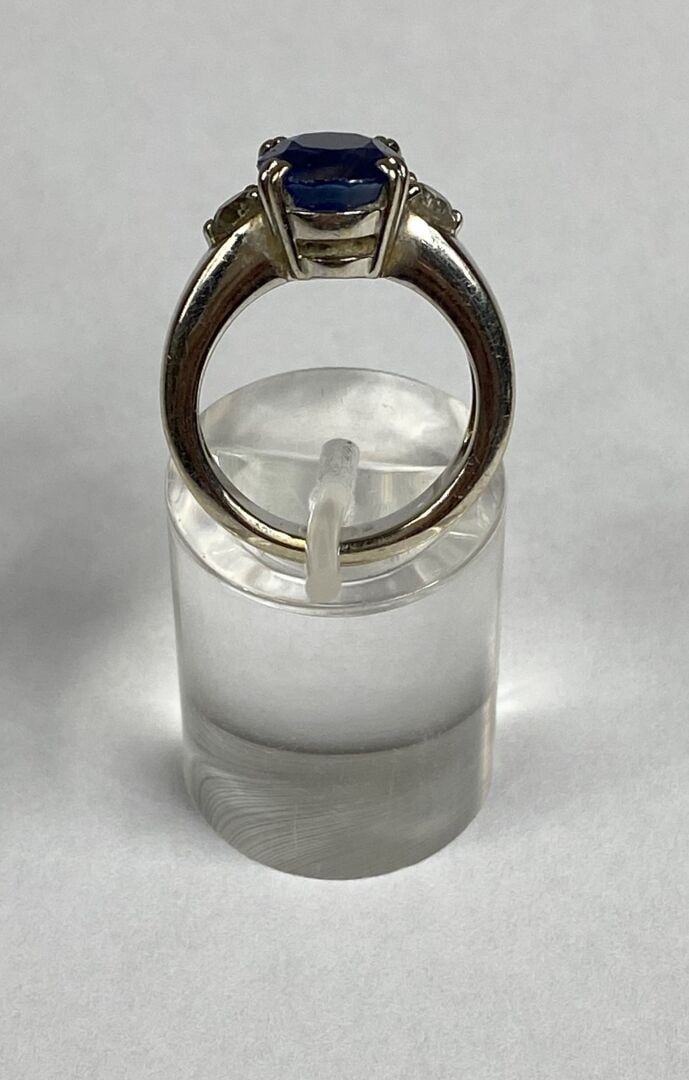 Bague jonc en or gris (750) ornée d'un saphir de taille ovale facettée en serti…