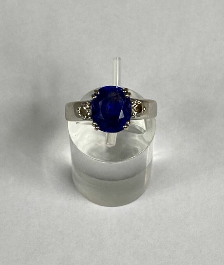 Bague jonc en or gris (750) ornée d'un saphir de taille ovale facettée en serti…