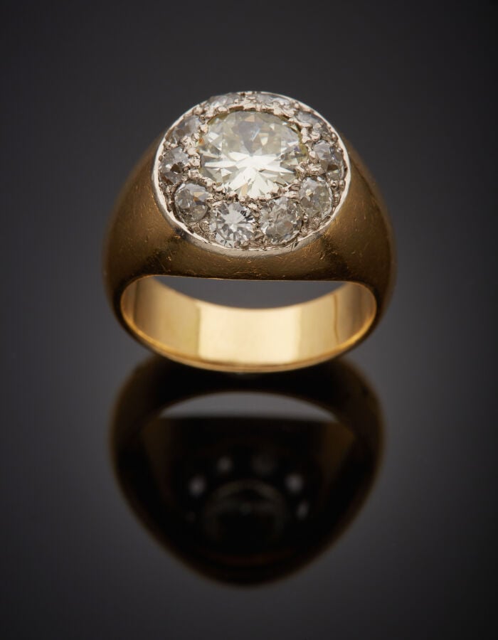BAGUE "jonc" en or jaune (750‰) centrée d'un motif circulaire pavé de onze diam…