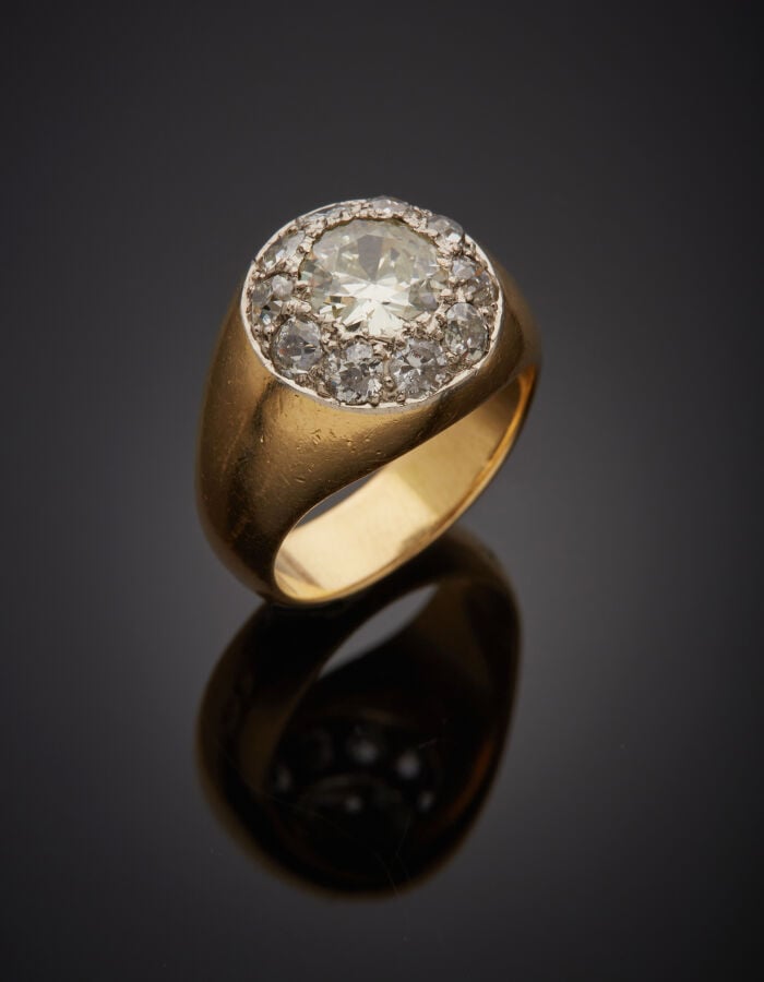 BAGUE "jonc" en or jaune (750‰) centrée d'un motif circulaire pavé de onze diam…