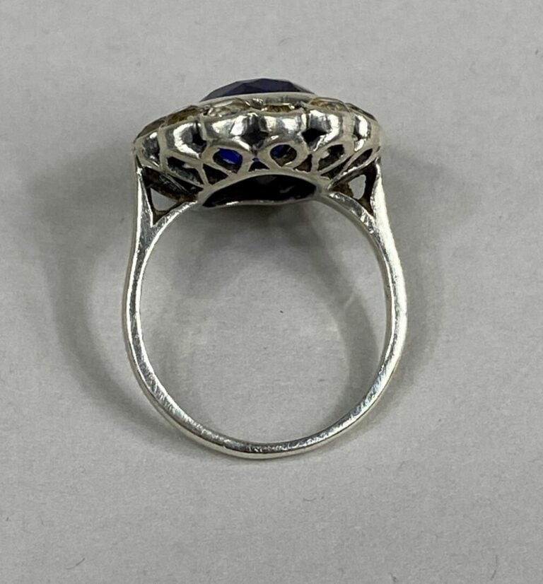 Bague marguerite en argent (925) ornée d'une pierre bleue ovale facettée dans u…