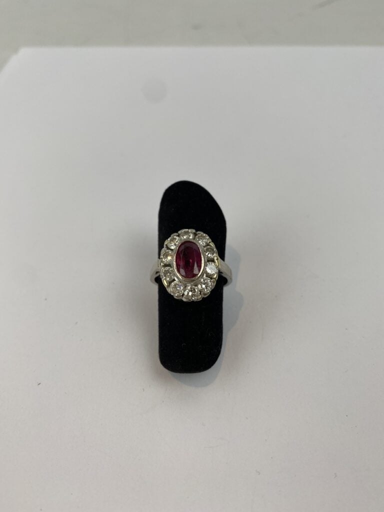 Bague marguerite en or gris (585) ornée d'un rubis de taille ovale facettée en…