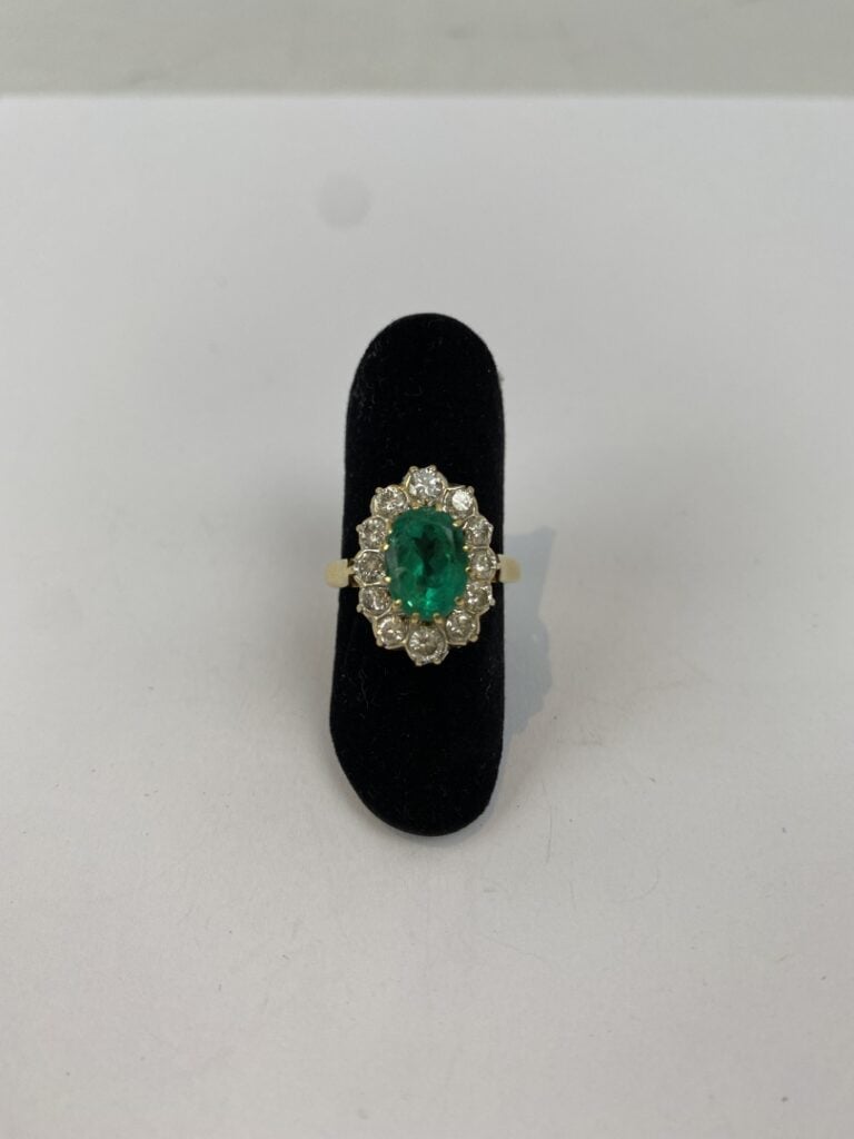 Bague marguerite en or jaune (750) ornée d'une émeraude de taille ovale facetté…