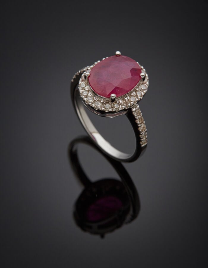 BAGUE ovale en or gris (750‰) ajouré, serti d'un rubis (inclusions), entouré et…