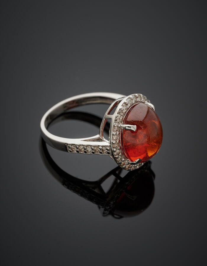 BAGUE ovale en or gris (750‰) serti d'une tourmaline orange cabochon, entourée…
