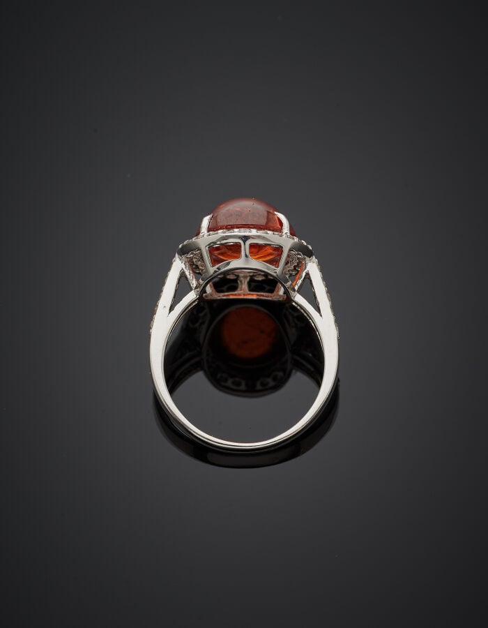 BAGUE ovale en or gris (750‰) serti d'une tourmaline orange cabochon, entourée…