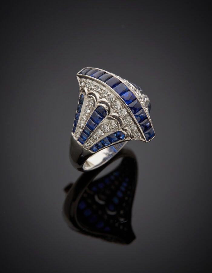 BAGUE « pont et palmettes » en platine (950‰) bombé, ajouré, serti de saphirs c…