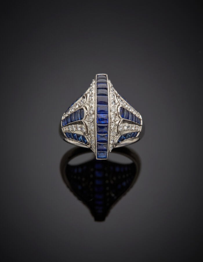 BAGUE « pont et palmettes » en platine (950‰) bombé, ajouré, serti de saphirs c…