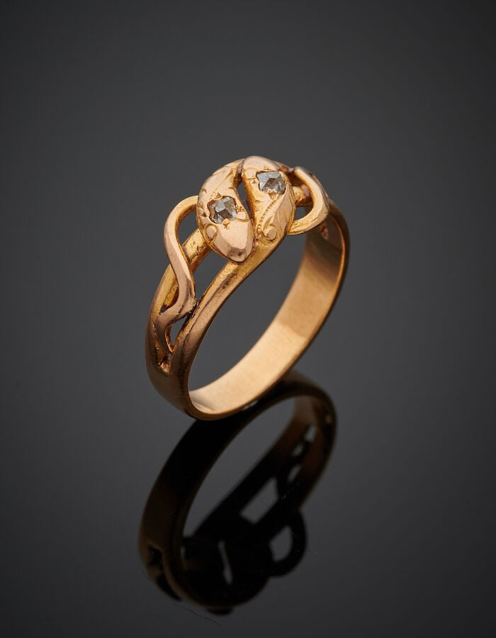 BAGUE "serpents entrelacés" en or rose (750‰) ajouré, ciselé, la tête sertie d'…