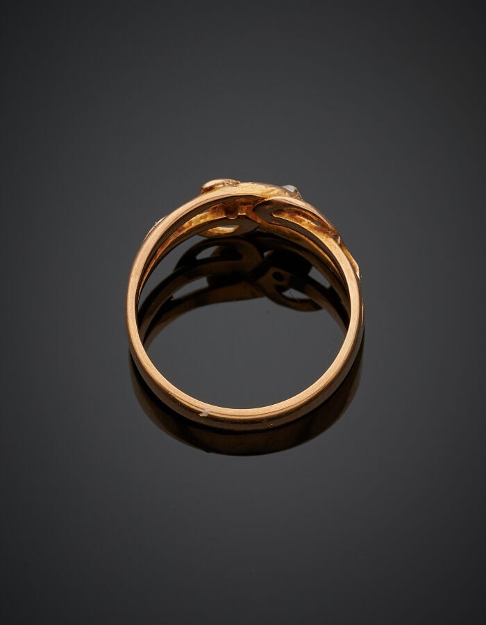 BAGUE "serpents entrelacés" en or rose (750‰) ajouré, ciselé, la tête sertie d'…