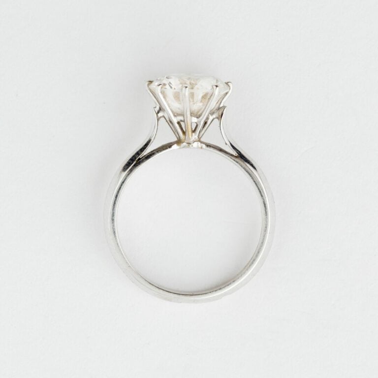 Bague solitaire en or gris ornée d'une pierre blanche facettée en serti griffe…