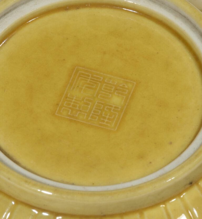 Boîte lenticulaire jaune en deux parties, à décor creusé de fleurs et volutes.…