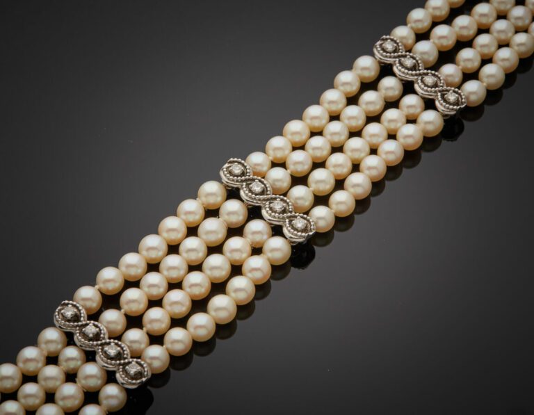 BRACELET composé de quatre rangs de perles de culture blanches, alternées de qu…