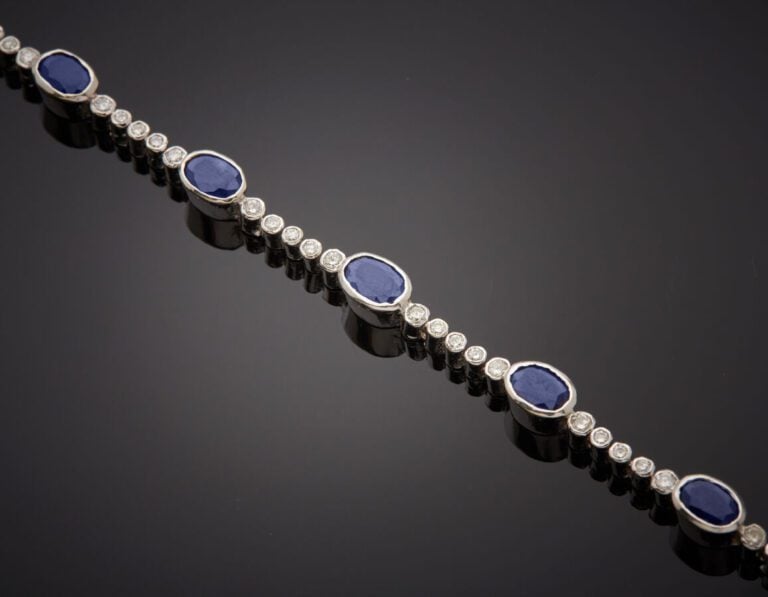 BRACELET en or gris (585‰) 14 carats, composé de dix saphirs ovales en serti cl…