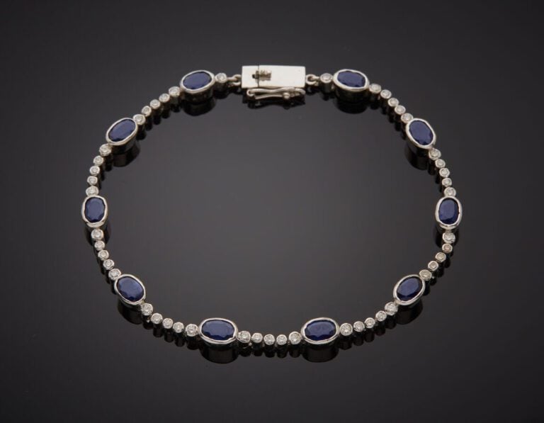 BRACELET en or gris (585‰) 14 carats, composé de dix saphirs ovales en serti cl…