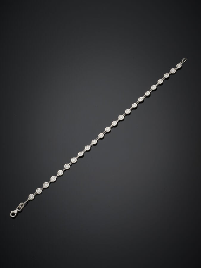 BRACELET en or gris (750‰) composé de 23 diamants taille brillant en serti clos…