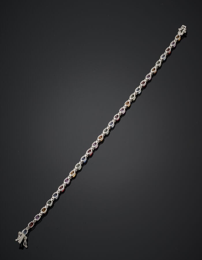 BRACELET en or gris (750‰) serti d'un alignement de saphirs multicolores ovales…