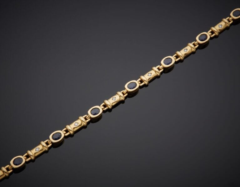 BRACELET en or gris (750‰) serti de dix saphirs ovales, alternés de dix petits…