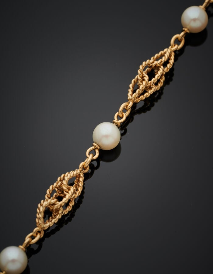 BRACELET en or jaune (750‰) à maillons entrelacés alternés de quatre perles de…