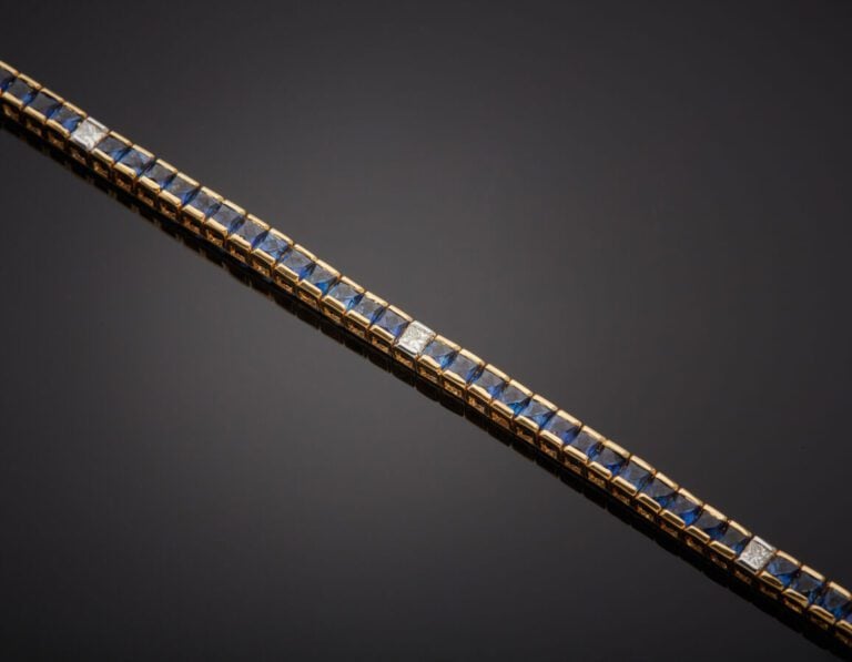 BRACELET en or jaune (750‰) serti d'un alignement de saphirs calibrés, alternés…
