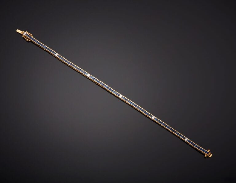BRACELET en or jaune (750‰) serti d'un alignement de saphirs calibrés, alternés…