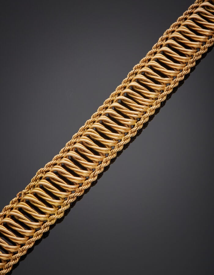 BRACELET "manchette" souple en or jaune (750‰) à maillons ovales torses entrela…