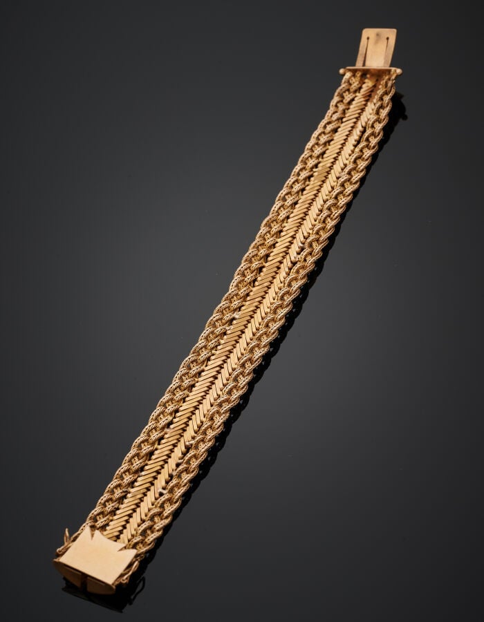 BRACELET "manchette" souple en or jaune (750‰) à motifs de chevrons bordés de t…