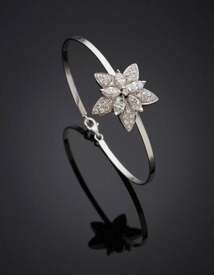BRACELET rigide en or gris (750‰) surmonté d'un motif « étoile » serti de diama…